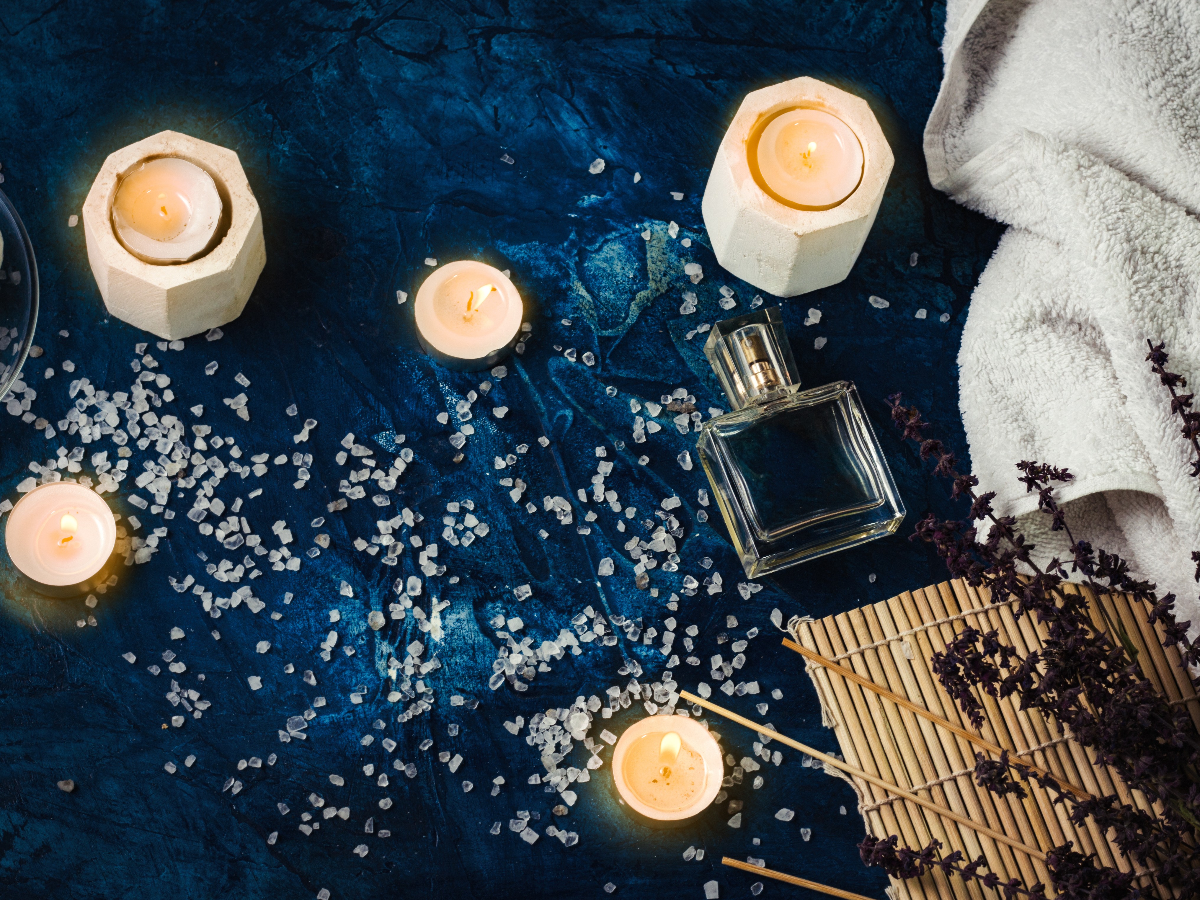 Candles and spa items on blue backdrop.