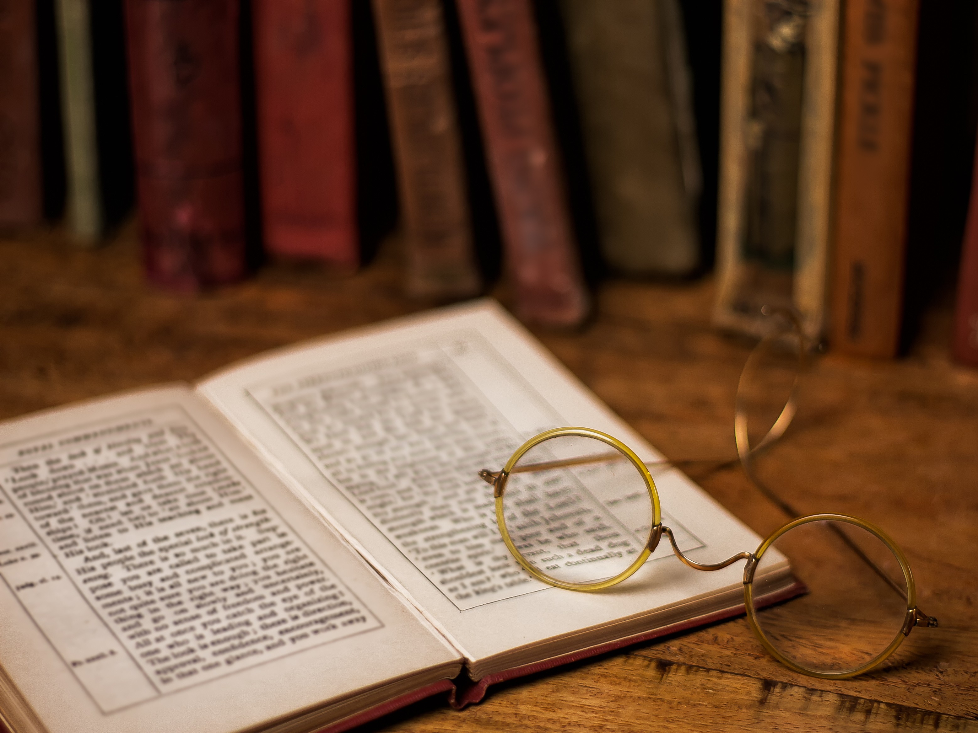 An old book with eyeglasses resting on it.